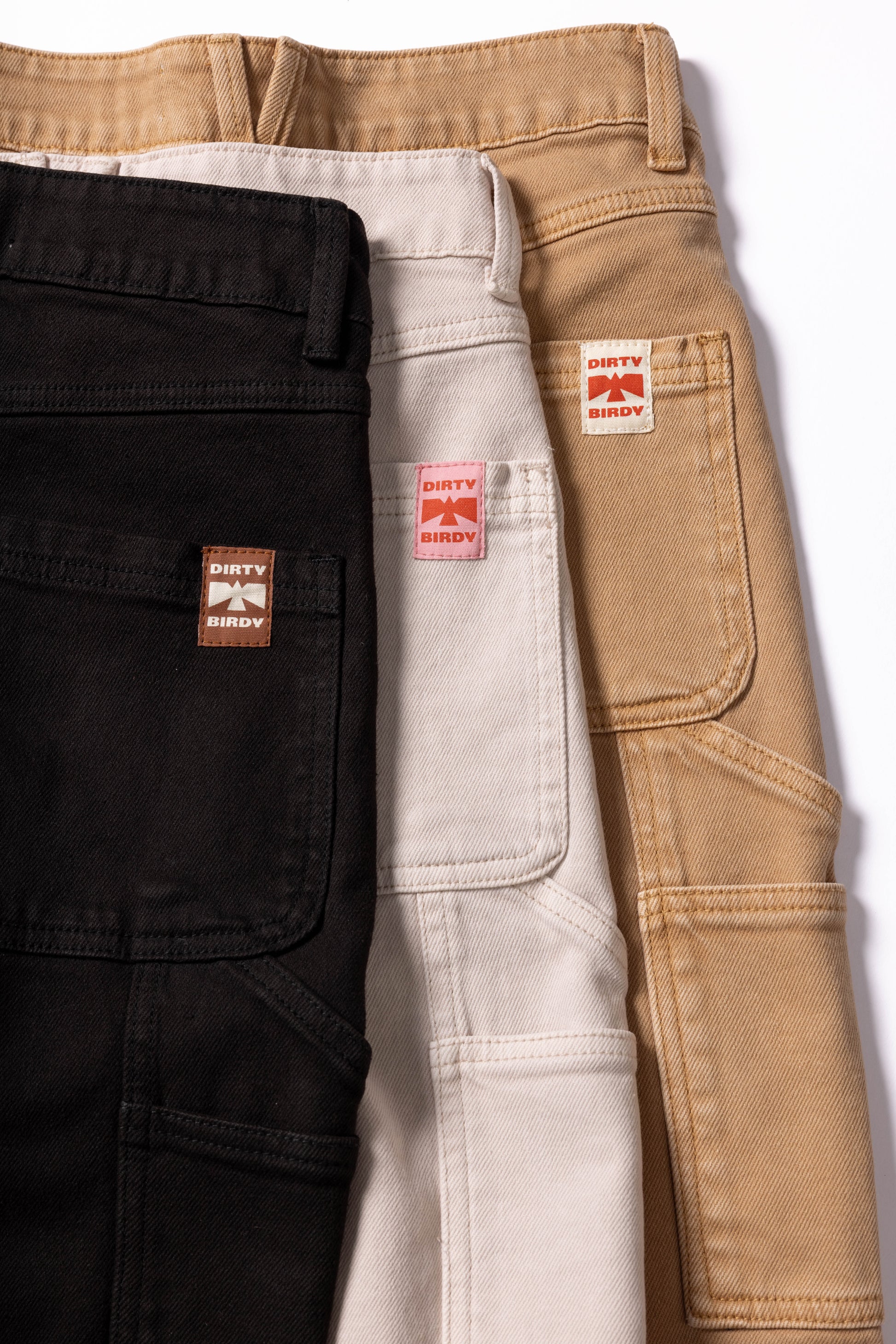 Dirty Birdy Carpenter Pant in three different colors, black, tan, and cream.